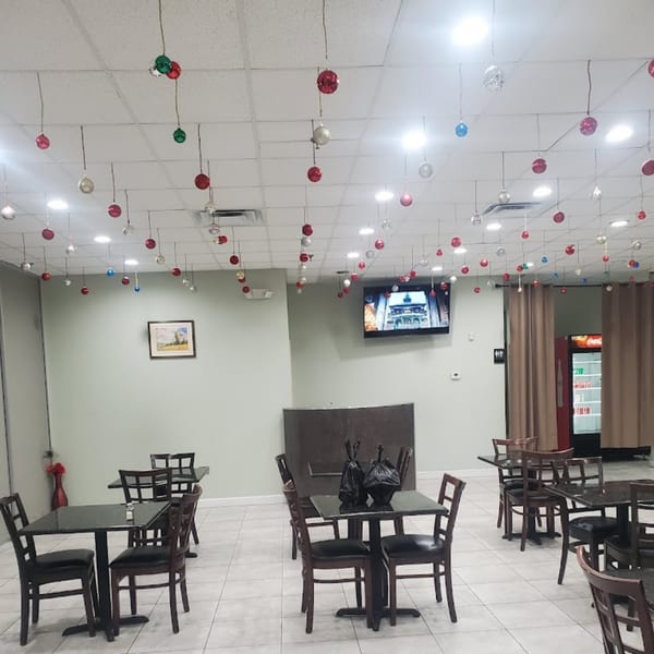 The Bombay Curry dining room features tables and chairs, with festive ornaments hanging from the ceiling.